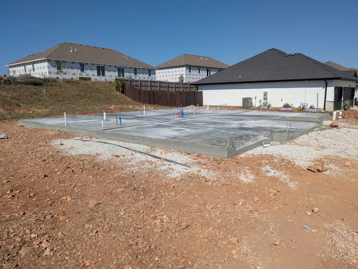 Wide view of a completed residential concrete foundation and prepared surrounding ground Wide view of a completed residential concrete foundation and prepared surrounding ground