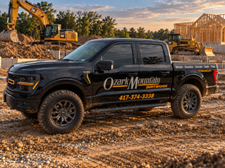 Ozark Mountain Dirtwork company truck with business logo and phone number on a job site Ozark Mountain Dirtwork company truck with business logo and phone number on a job site